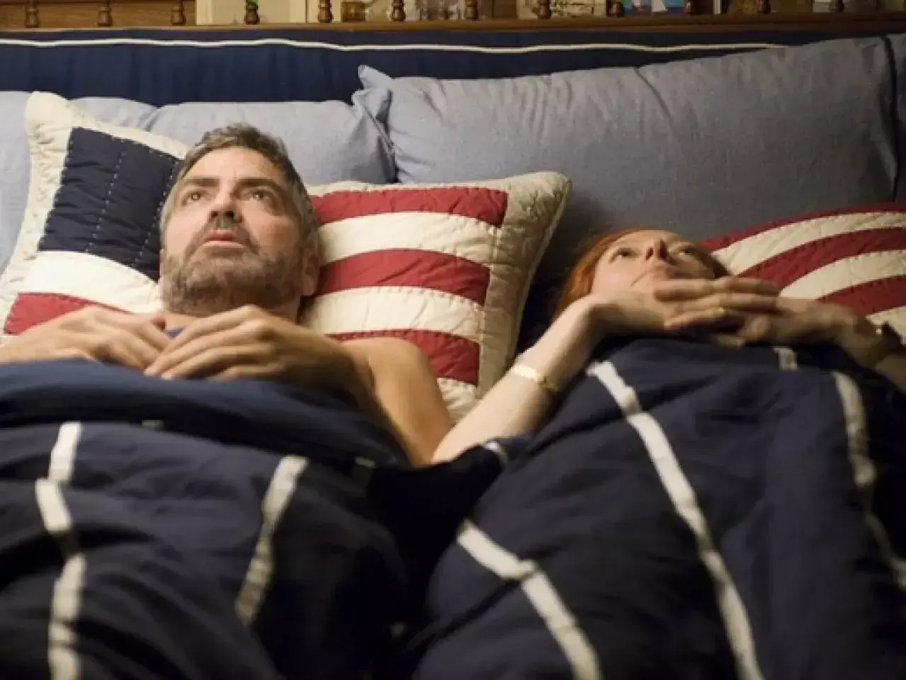 Il cast di Burn After Reading, a prova di spia, in un letto. George Clooney e Tilda Swinton sembrano preoccupati.