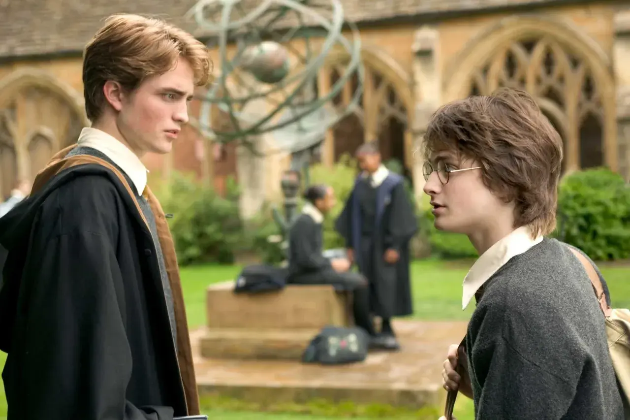 Robert Pattinson, chi ha interpretato Cedric Diggory, parla con Harry Potter nel cortile di Hogwarts.