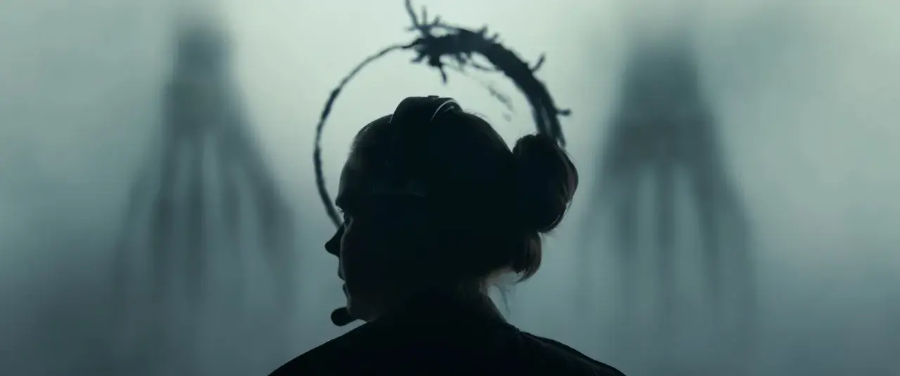 La protagonista di Arrival, in una scena chiave per la recensione, affronta l'ignoto. Le sagome aliene incombono.
