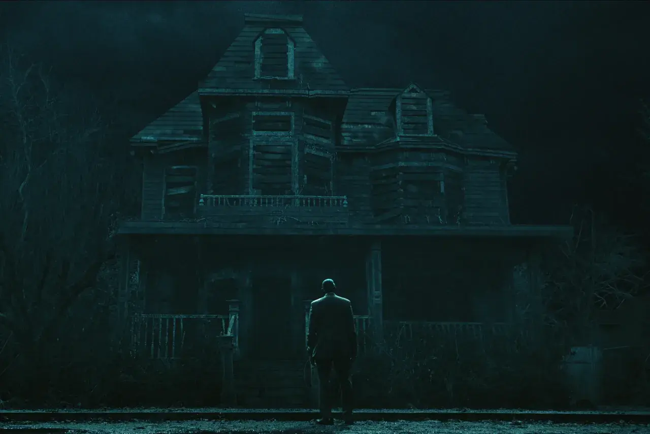 Un uomo osserva la sinistra Casa degli Usher, un'immagine che evoca le atmosfere de "La caduta della casa degli Usher recensioni".