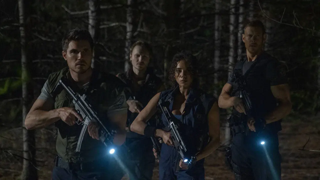 Quattro personaggi armati e con torce si muovono cauti nel bosco, pronti ad affrontare pericoli. Resident Evil: Welcome to Raccoon City recensioni.
