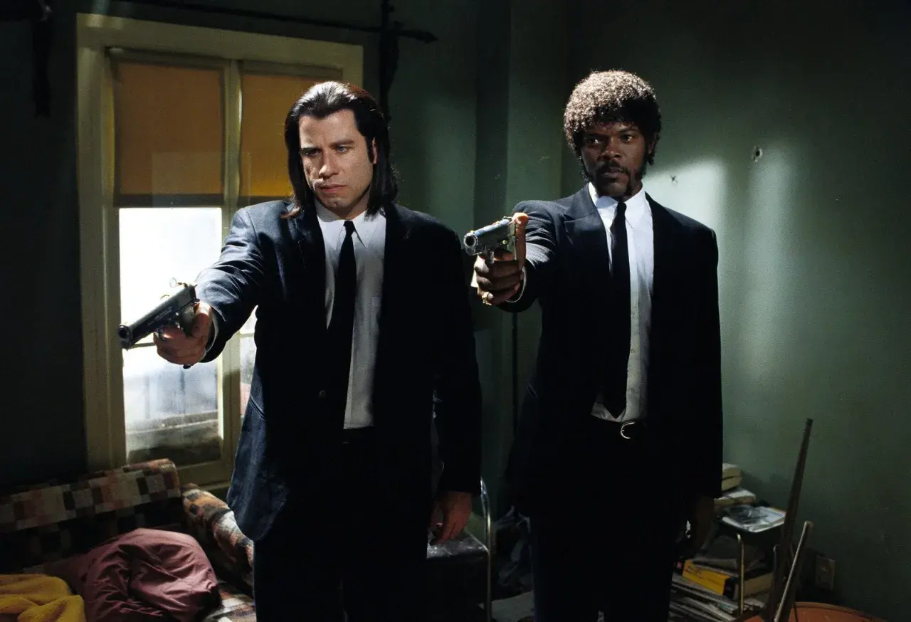 Samuel L Jackson e John Travolta in Pulp Fiction, con pistole puntate, pronti all'azione.