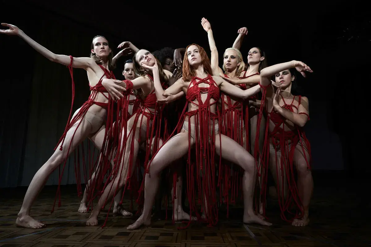 Danzatrici in abiti rossi intrecciati, un'immagine evocativa per la recensione di Suspiria 2018.