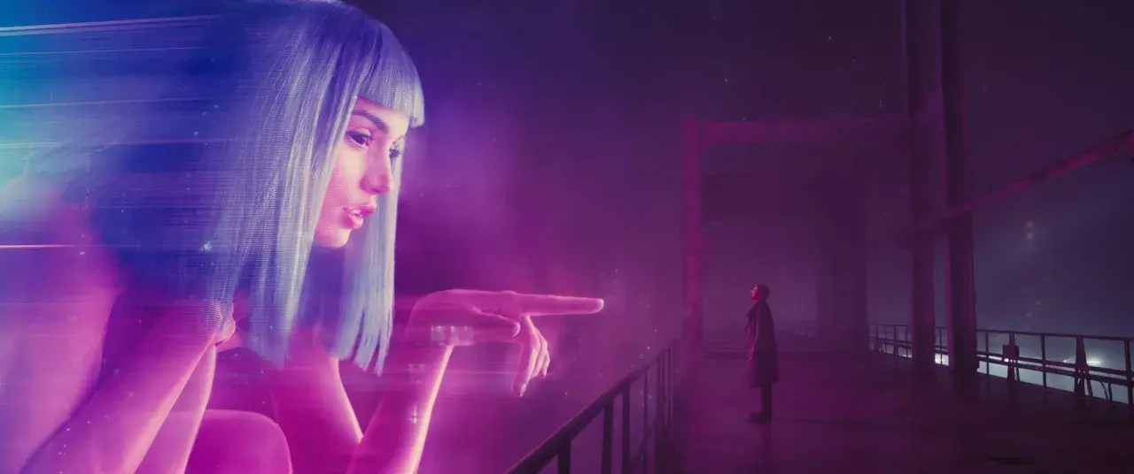 Joi, un'ologramma, interagisce con K su un ponte. Un'immagine iconica per la blade runner 2049 recensione.