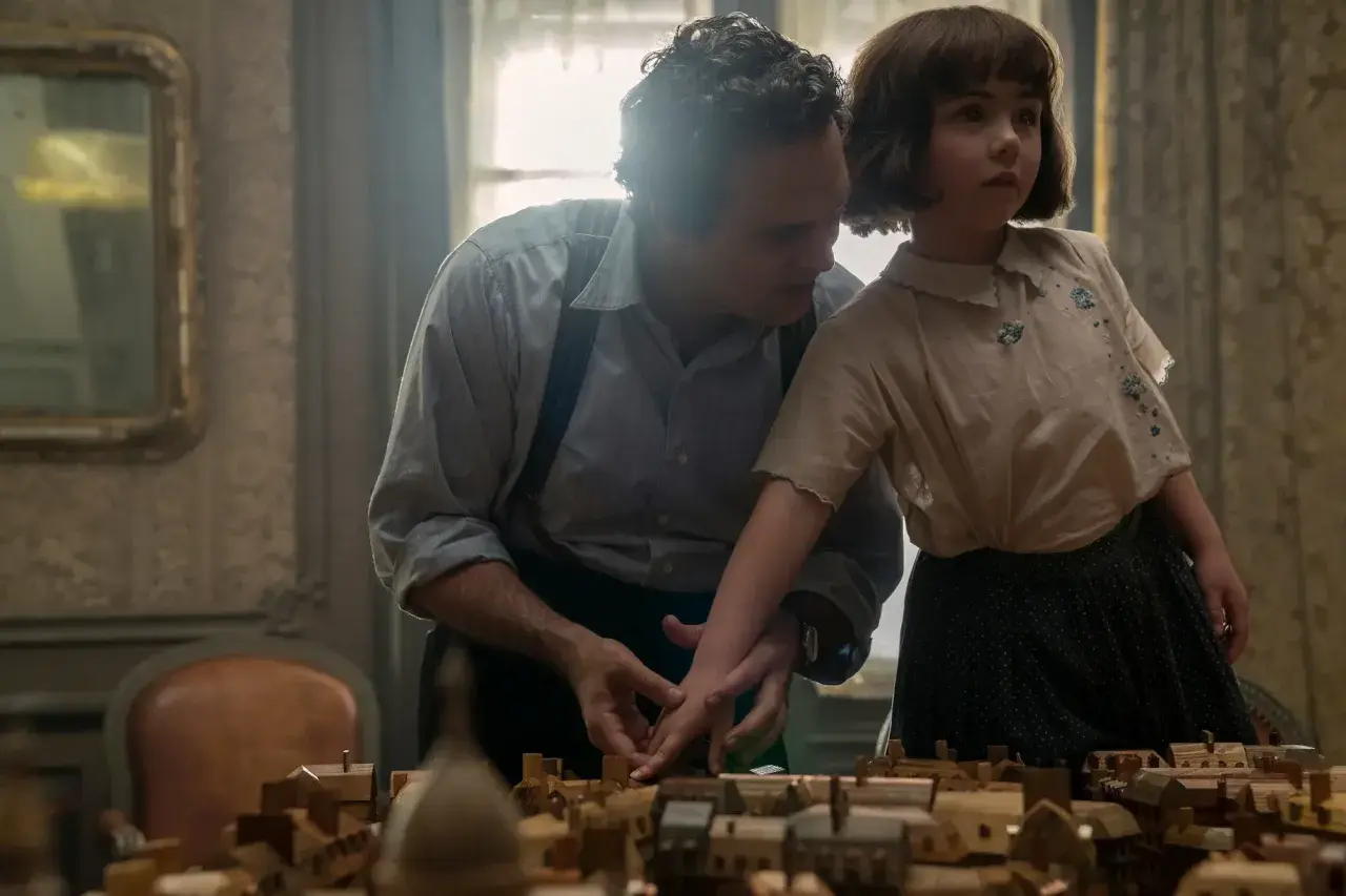 Un uomo e una bambina osservano un plastico di città. Un momento che evoca "tutta la luce che non vediamo recensioni".