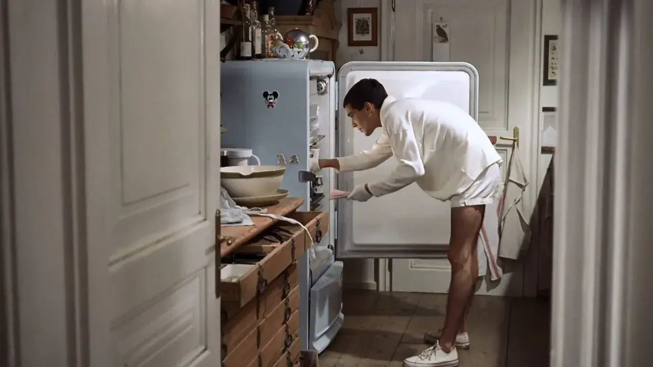 Ragazzo in pigiama cerca qualcosa nel frigo, forse il finale dei funny games.