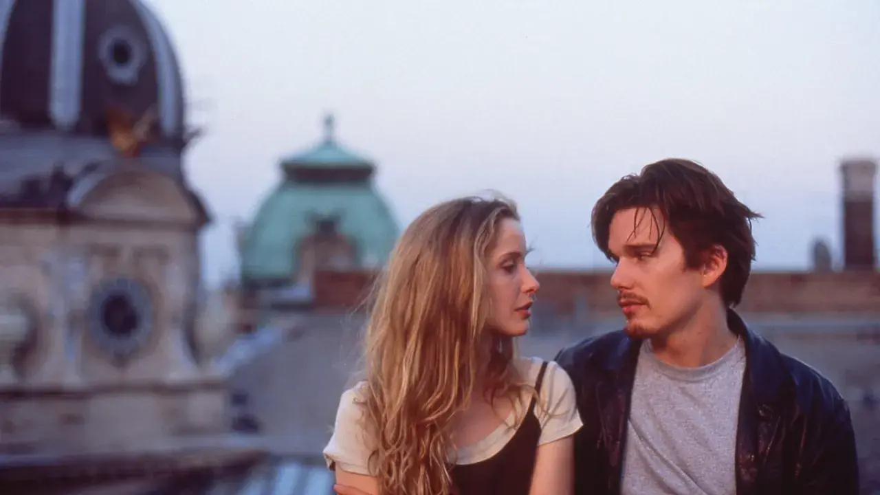 Jesse e Celine, protagonisti della trilogia before, si guardano intensamente sui tetti di Vienna.