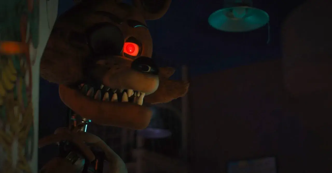 Occhio rosso minaccioso per la recensione di Five Nights at Freddy's. L'animatronic Foxy si avvicina nell'ombra.