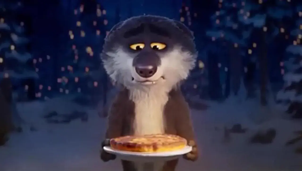 Un lupo dei lupis, con un'espressione un po' malinconica, offre una torta in un bosco illuminato da lucine.