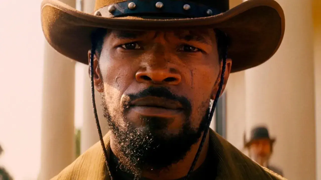 Primo piano di Django, con cappello da cowboy e barba. Il suo sguardo intenso evoca il significato di libertà e vendetta in Django Unchained.