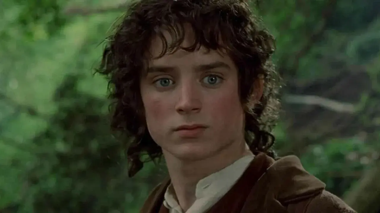 Primo piano di Elijah Wood nei film de Il Signore degli Anelli, con occhi azzurri penetranti e capelli castani mossi.