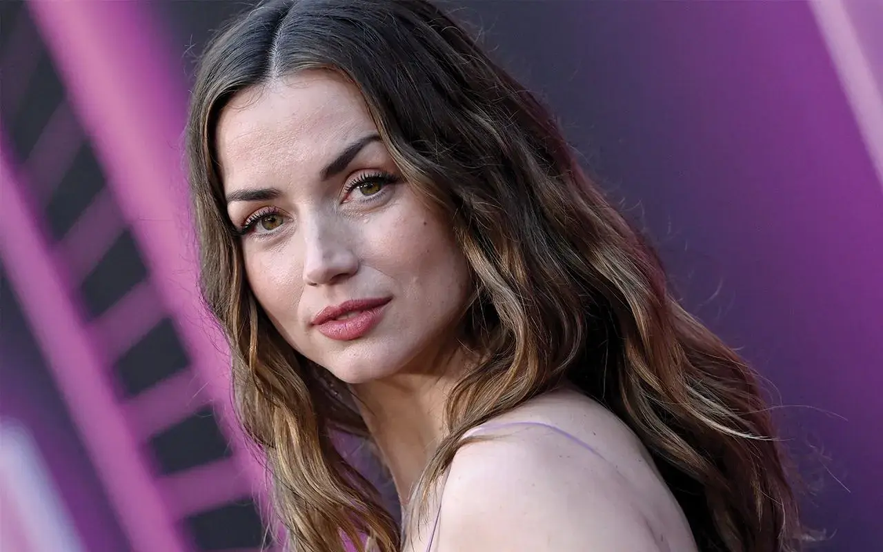 Primo piano di Ana de Armas giovane, con capelli castani mossi e sguardo intenso.
