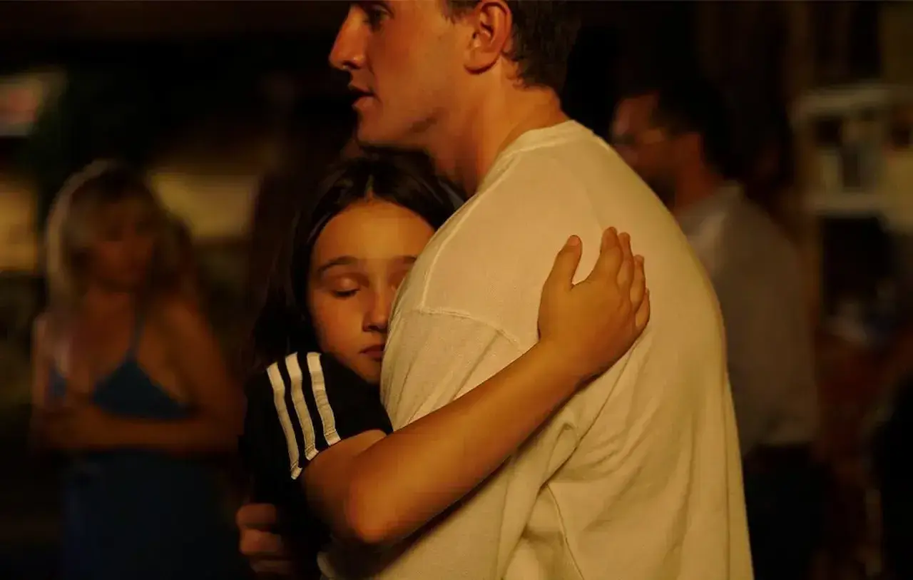 Un abbraccio intenso, una bambina si stringe a un uomo. Una scena che fa pensare a un momento di conforto, quasi una spiegazione dopo il sole.