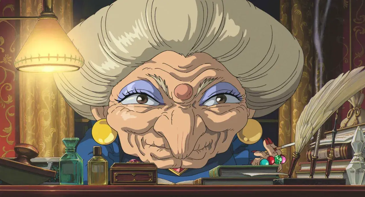 La strega Yubaba, figura chiave de "La città incantata", con il suo sguardo penetrante e la sua scrivania piena di oggetti misteriosi.
