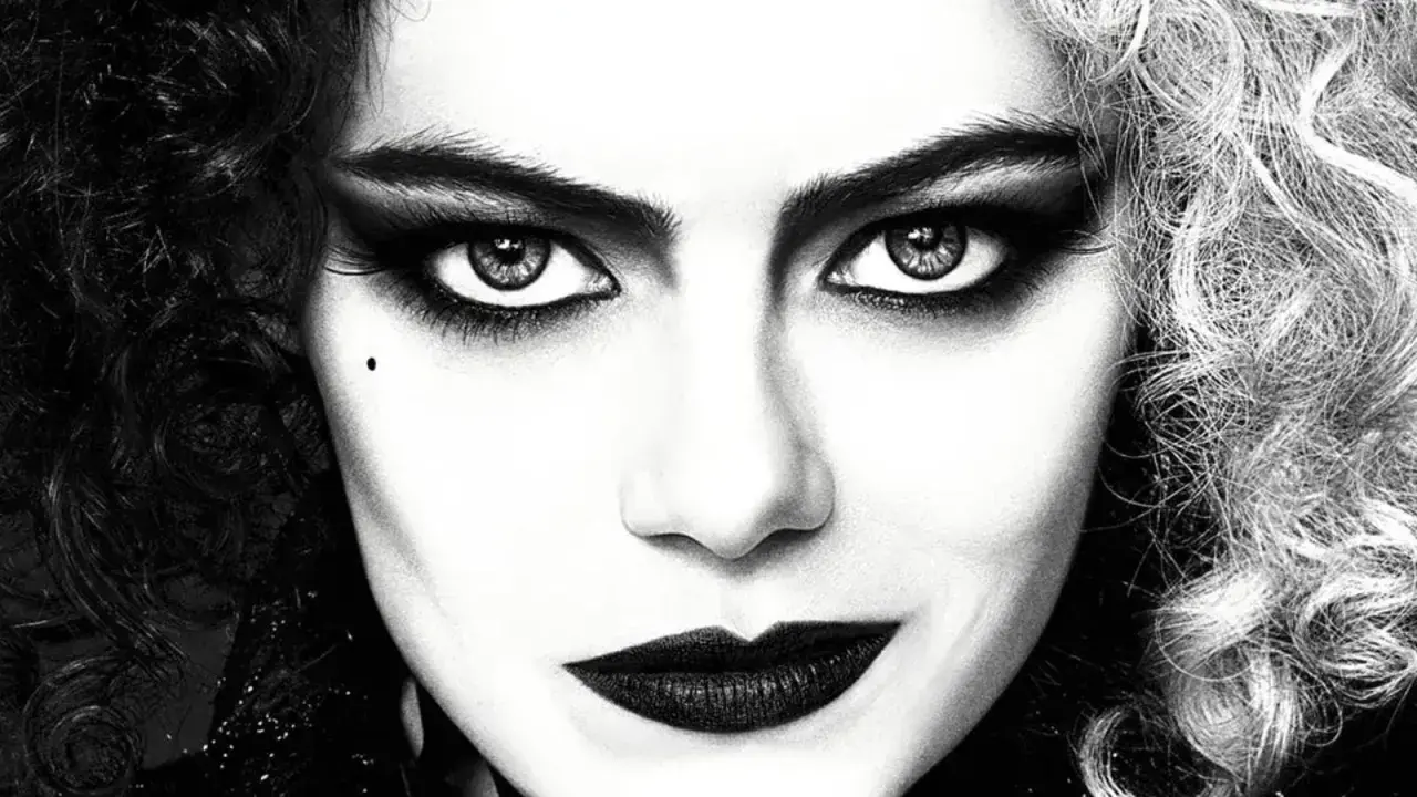 Primo piano di Cruella con capelli bicolore, trucco drammatico e labbra scure. Le sue recensioni sono sempre intense.