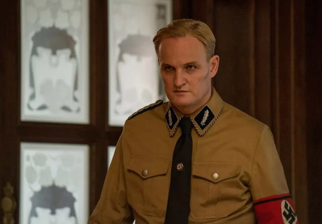 L'uomo dal cuore di ferro, in uniforme, con sguardo severo. Le recensioni lo descrivono come un personaggio complesso.