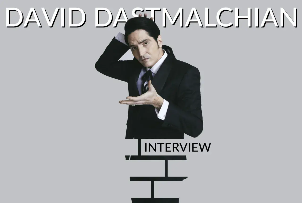 David Dastmalchian in un completo elegante, pronto per un'intervista.