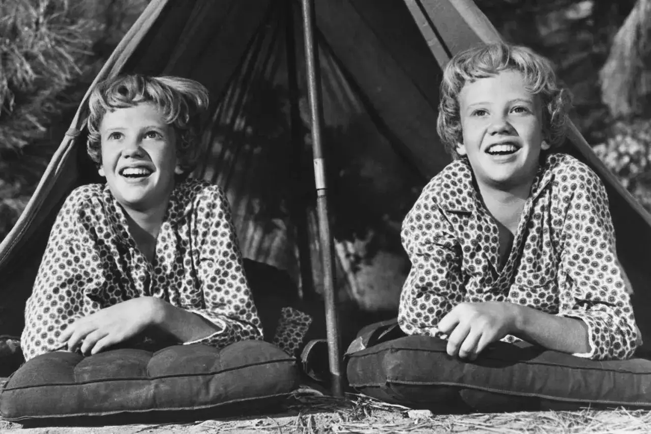 Le gemelle Hayley Mills ridono felici in tenda, pronte per un'avventura.
