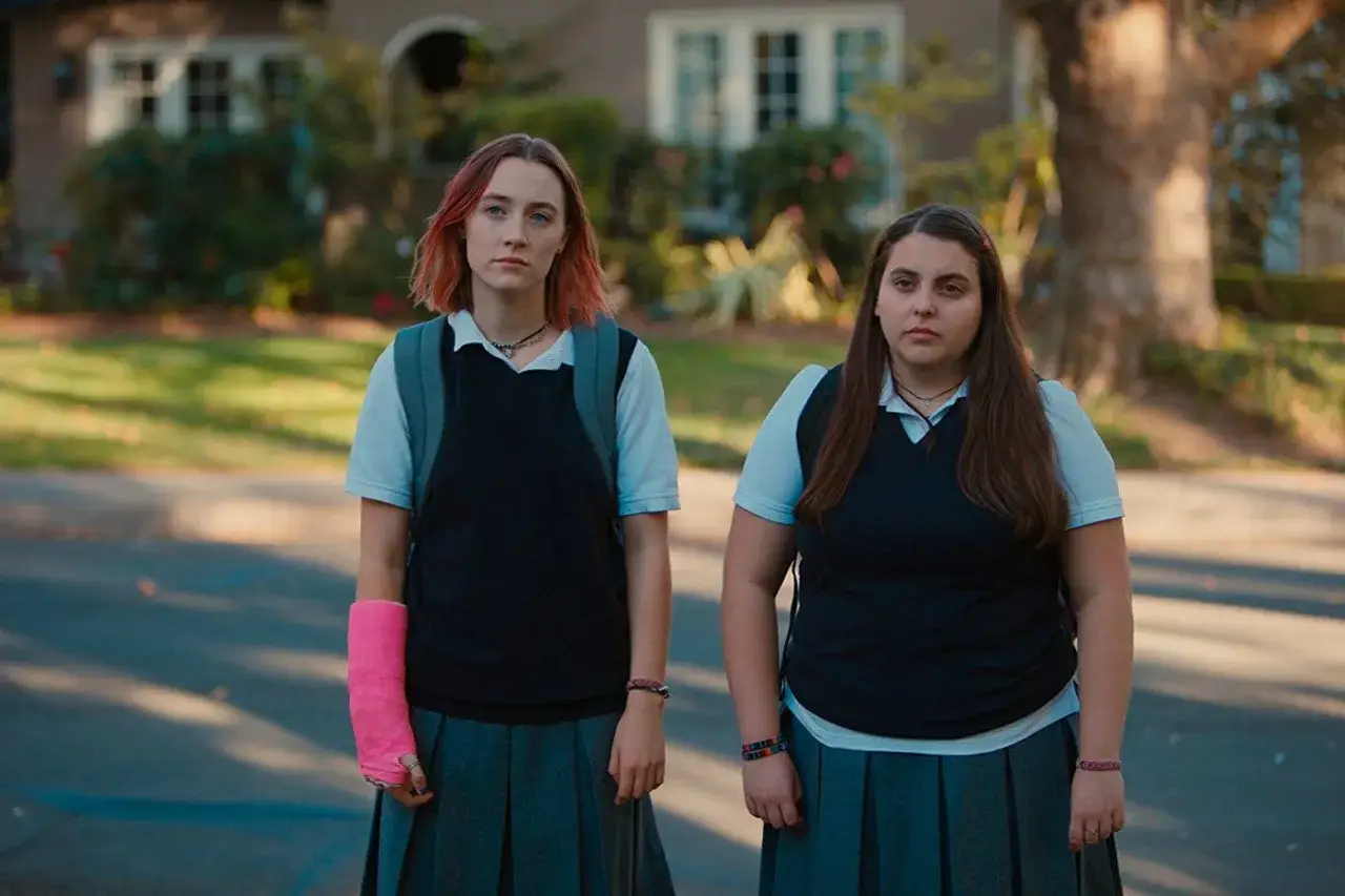Due adolescenti, una con un gesso rosa, in uniforme scolastica. Lady Bird recensione: un ritratto di crescita.