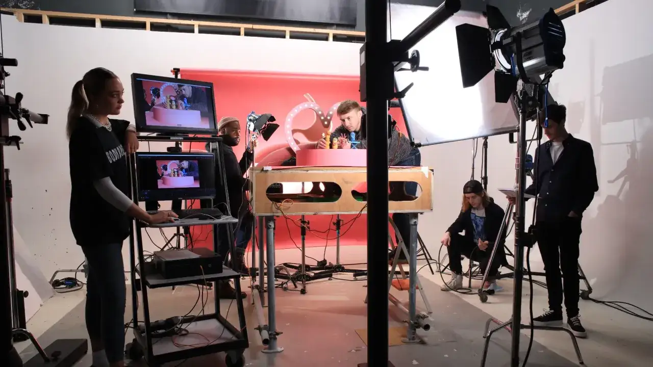 Team al lavoro per un stop motion film. Luci, monitor e set con personaggi colorati.