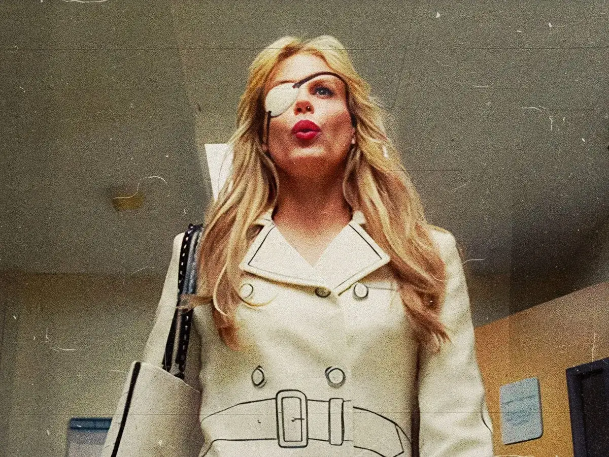 La protagonista di Kill Bill, con la sua iconica benda sull'occhio, sfoggia un trench bianco e labbra rosse.