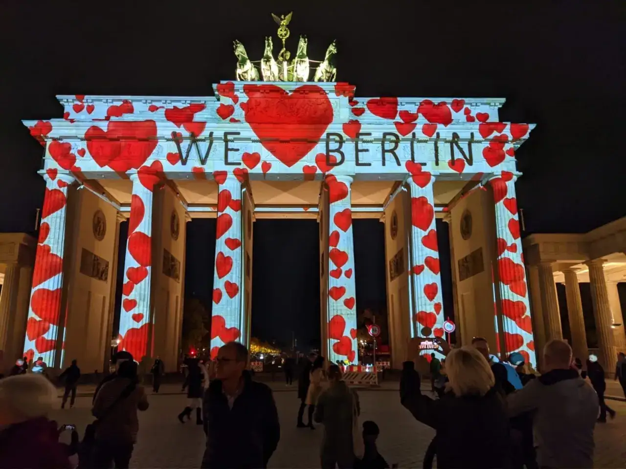 Porta di Brandeburgo illuminata da cuori rossi, con la scritta