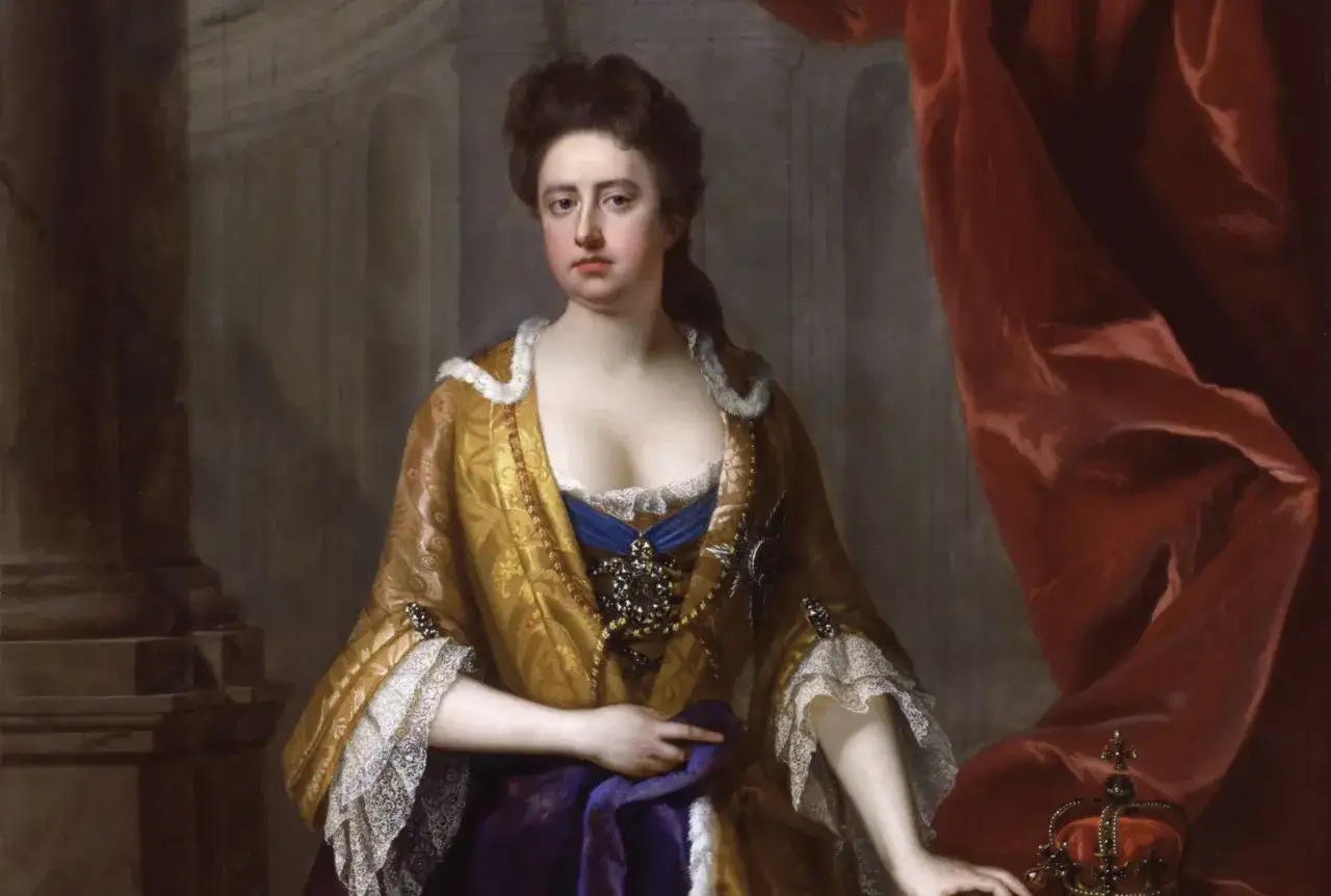 Ritratto di Regina Anna la favorita, con sontuosi abiti dorati e gioielli, accanto a una corona e drappi rossi.