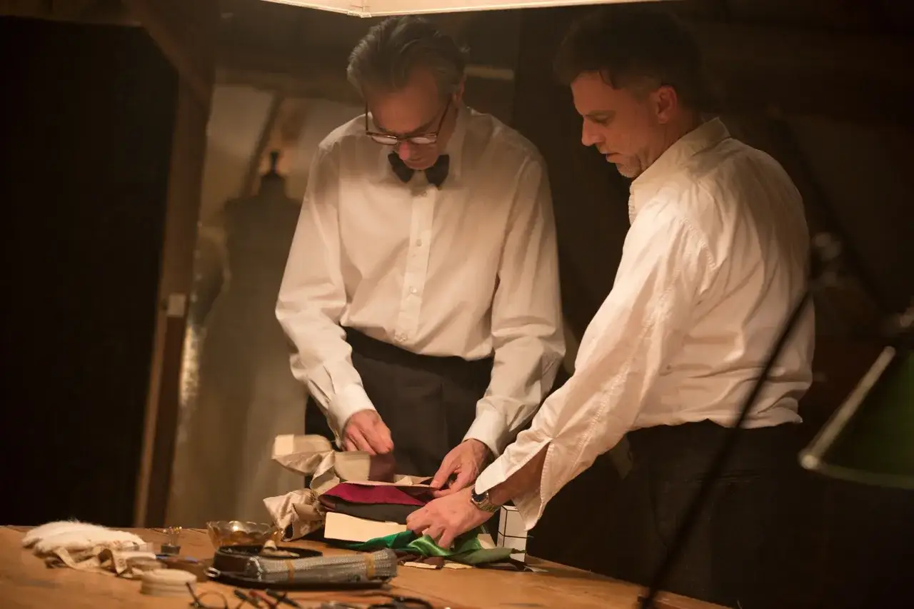 Daniel Day-Lewis, nei panni di un meticoloso calzolaio, esamina tessuti pregiati.