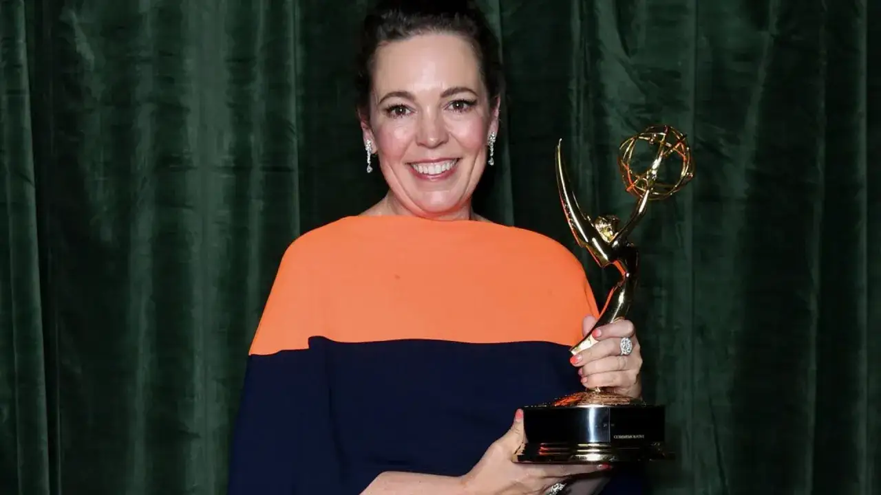 Olivia Colman sorride felice tenendo un Emmy, uno dei tanti premi vinti da Olivia Colman.