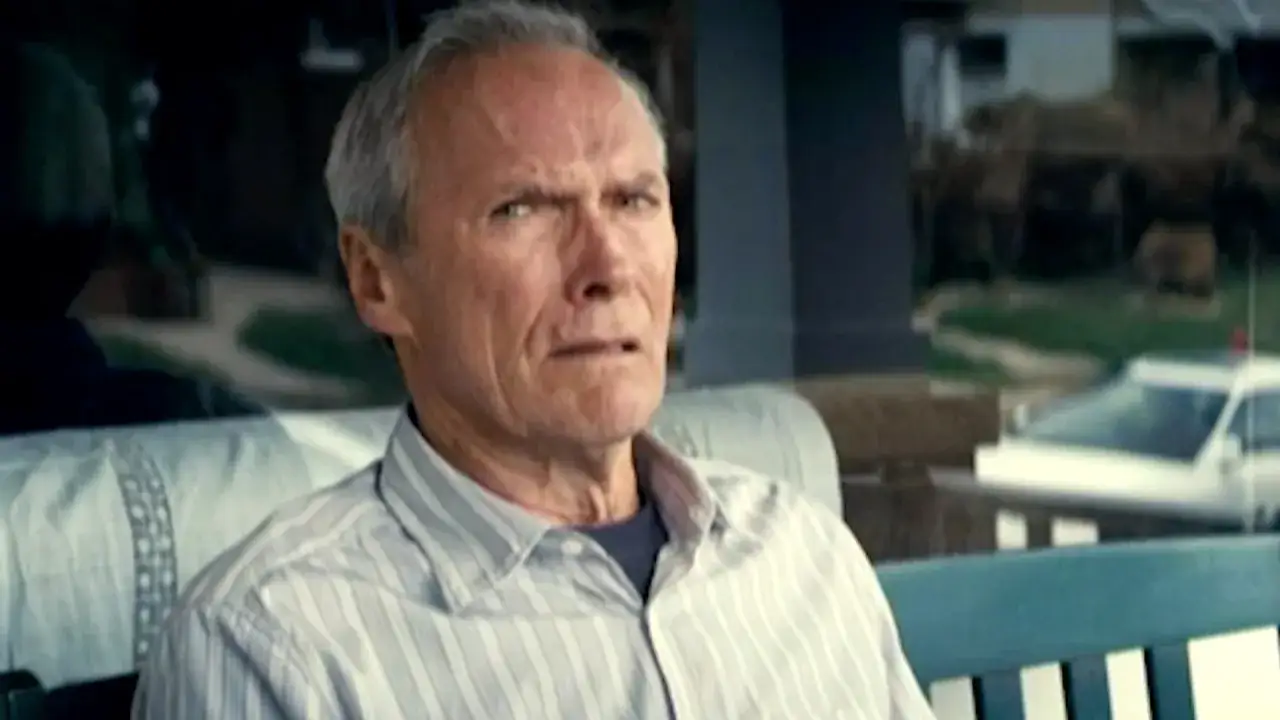 Clint Eastwood pensieroso, il volto segnato dal tempo, riflette sul gran torino film significato.