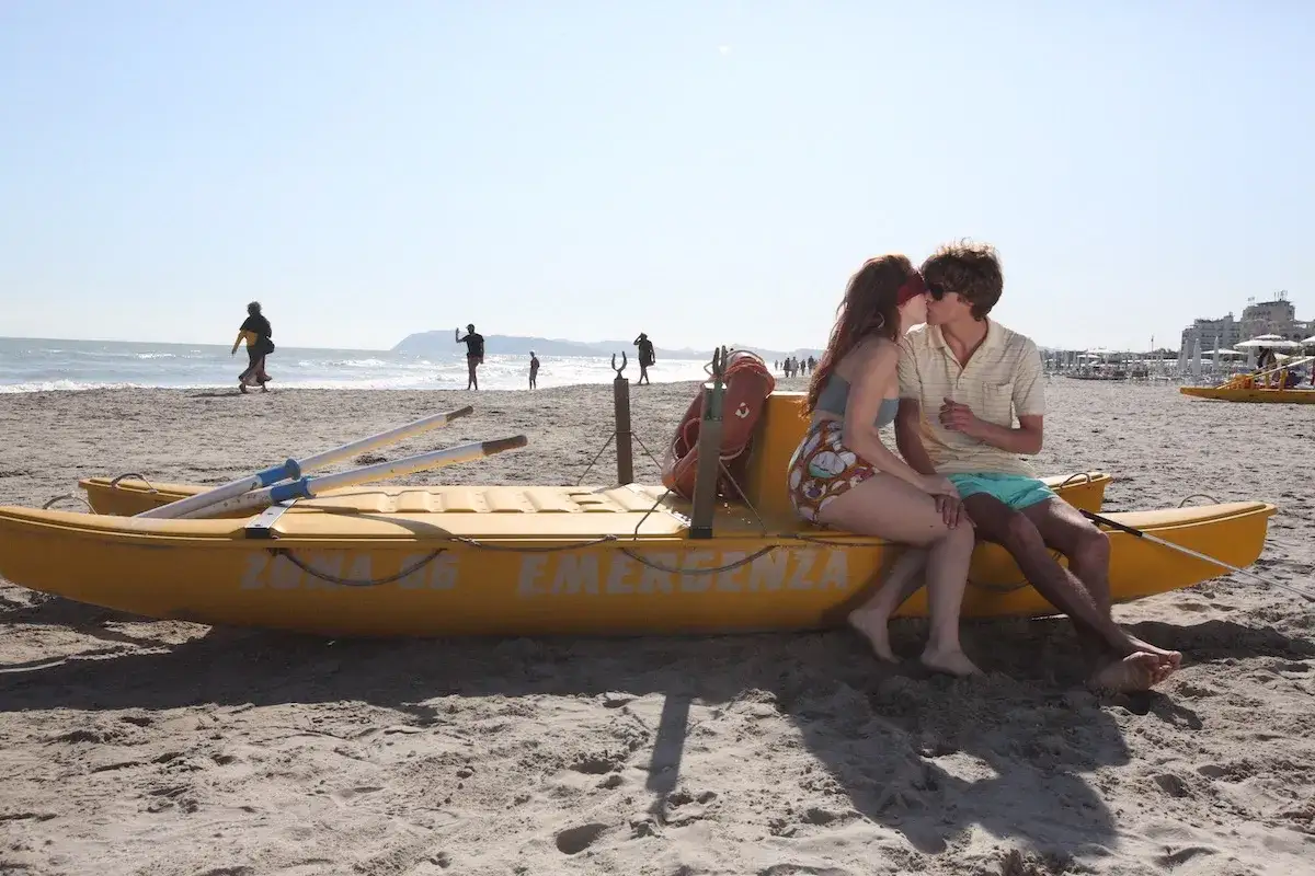 Coppia baciarsi su una barca gialla, sotto il sole di Riccione. Le recensioni per questa spiaggia sono ottime!