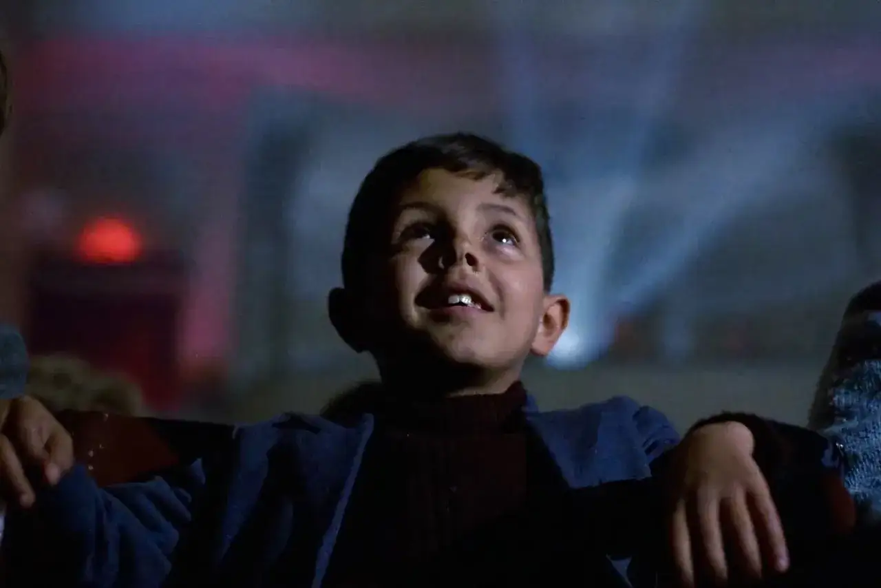 Un bambino incantato guarda il soffitto, come in una scena di Nuovo Cinema Paradiso. Le recensioni lo descrivono come un'icona di gioia pura.