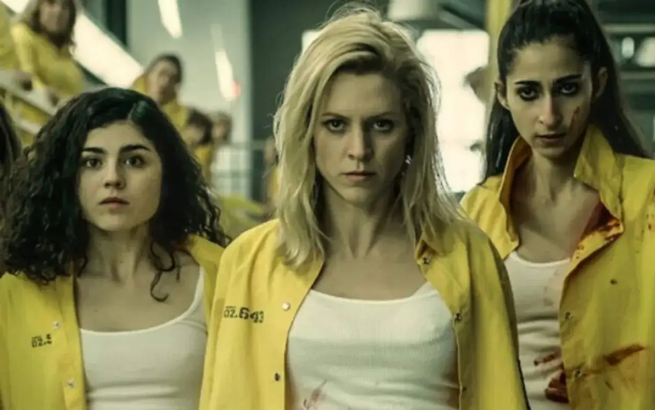 Tre donne con divise gialle, forse in prigione, con espressioni serie. La trama di Vis a Vis è intensa.