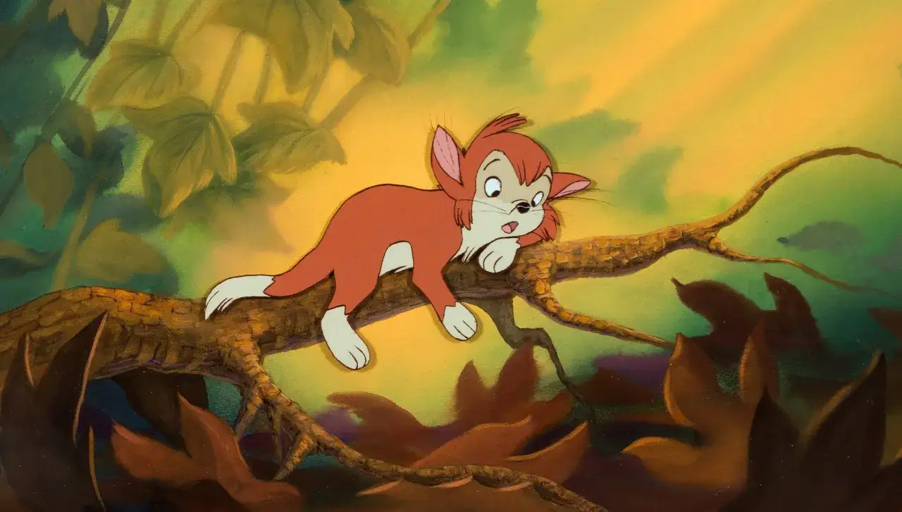 Un gattino rosso, protagonista di un film di Don Bluth, si riposa su un ramo tra foglie autunnali.