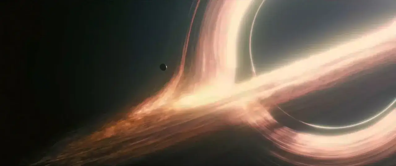 Un pianeta orbita vicino a un buco nero, un'immagine mozzafiato che cattura l'essenza di una recensione di Interstellar.