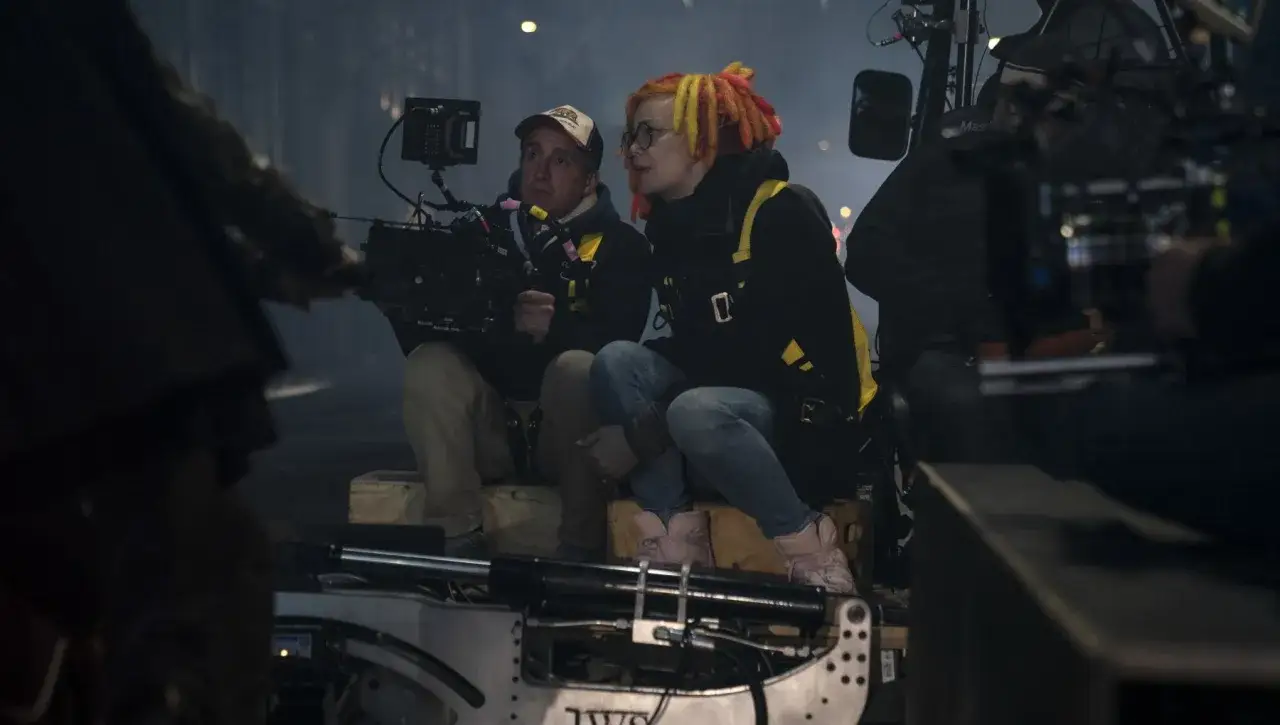 Daniele Massaccesi e una collega osservano attentamente il set, immersi nell'atmosfera di un film.